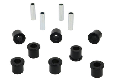 A set of black synthetic elastomer bushings and metal sleeves for vehicle control arms.